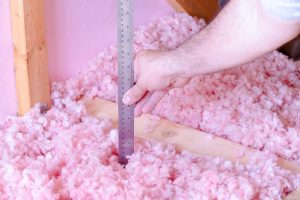 Check the energy efficiency of their house by measuring the thickness of fiberglass insulation in the attic