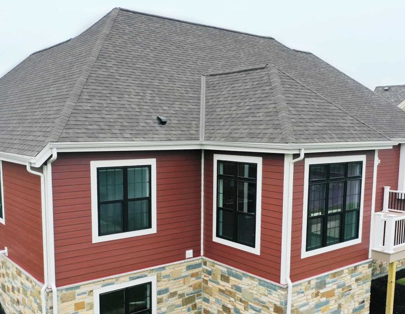 Exterior_windows_on-red-siding-house vinyl black windows fit Northwest indiana's extreme weather